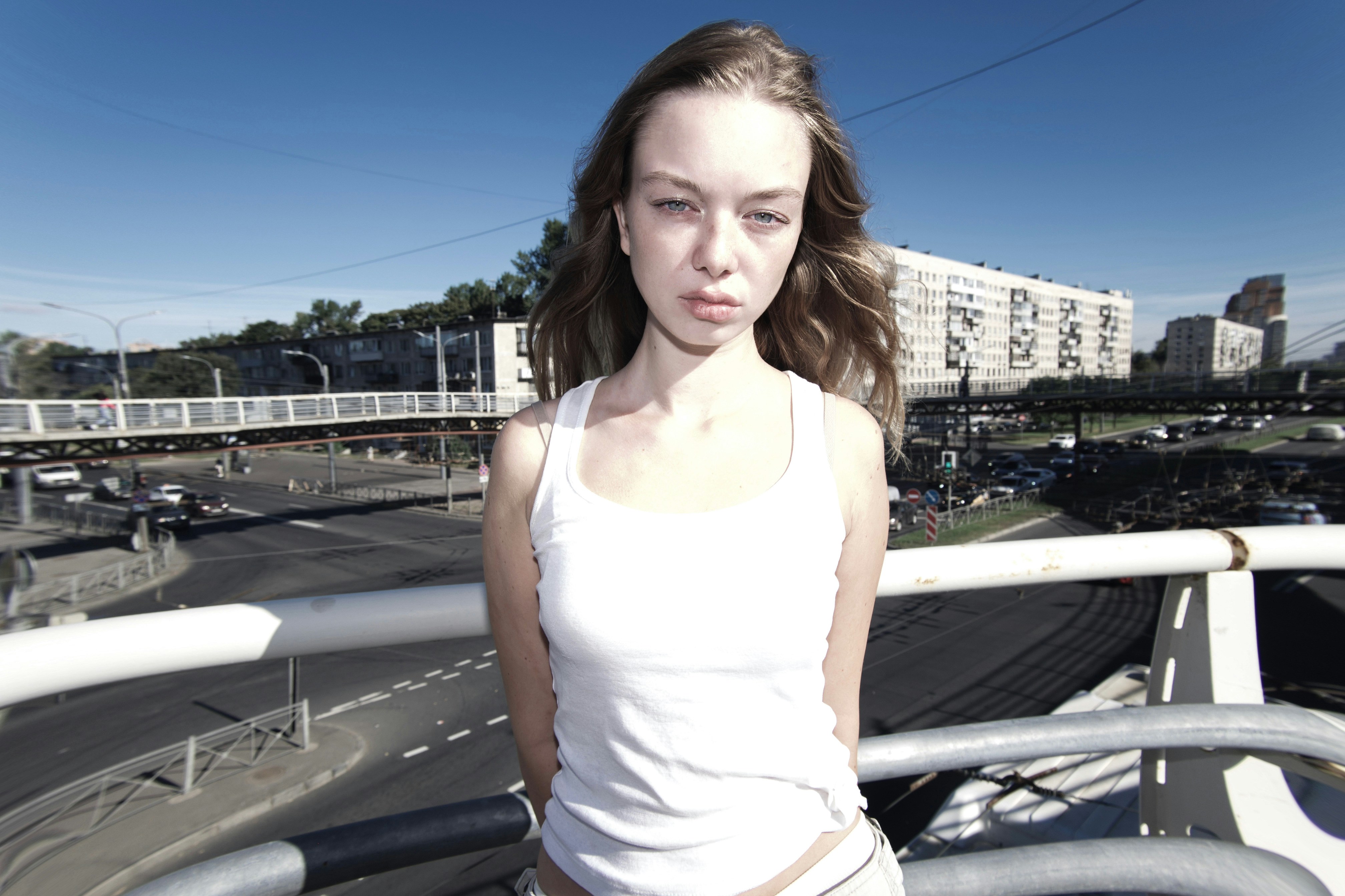 A woman standing on a balcony with a city street in the background